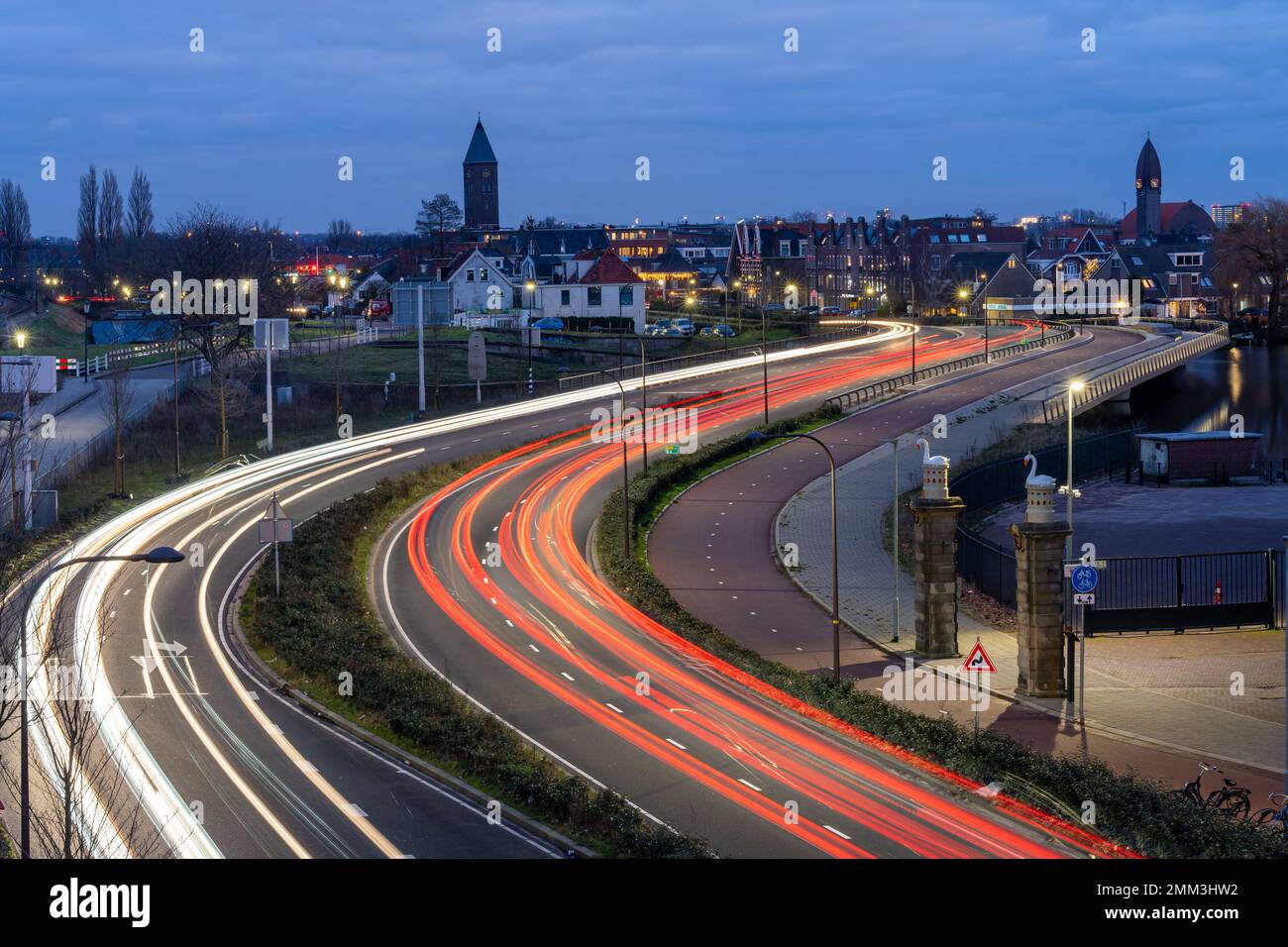 Lunga esposizione del traffico serale su un'autostrada vista dalla stazione ferroviaria Halfweg Zwanenburg nei Paesi Bassi Foto Stock