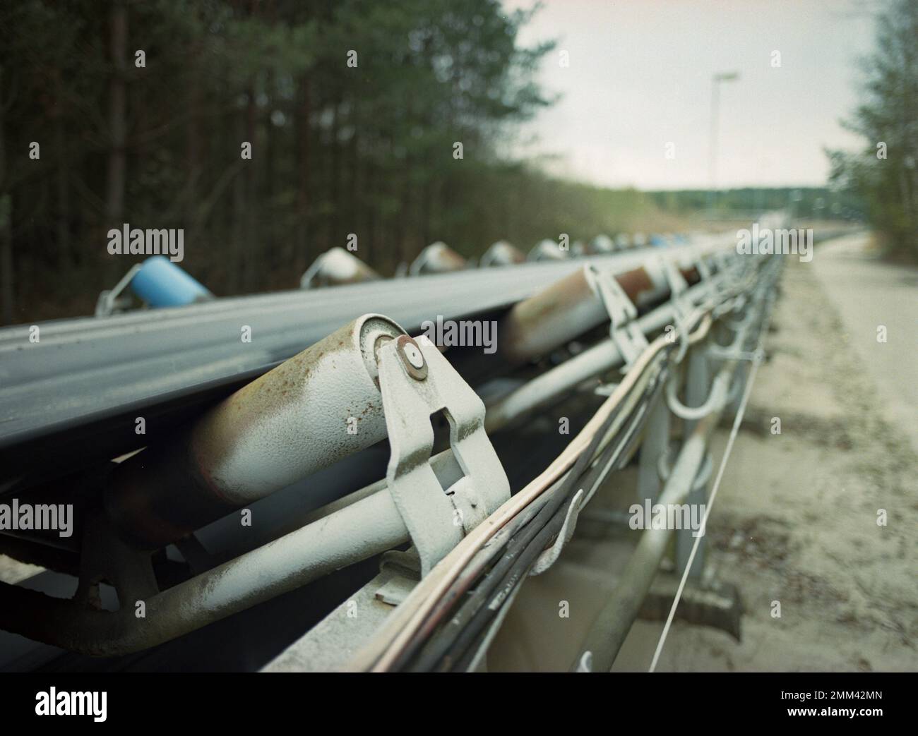 Dettaglio poco profondo di un trasportatore utilizzato per trasportare sabbia nella zona dei pozzi di sabbia vicino a Provodín, nella parte settentrionale della Repubblica Ceca. Ripresa su pellicola. Foto Stock