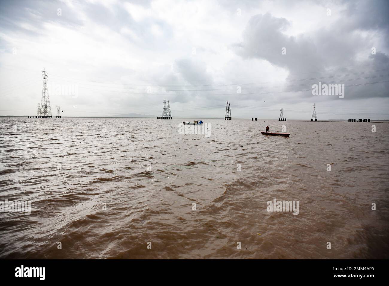 Barche da pesca in mare con torri Tall Electric sullo sfondo Foto Stock