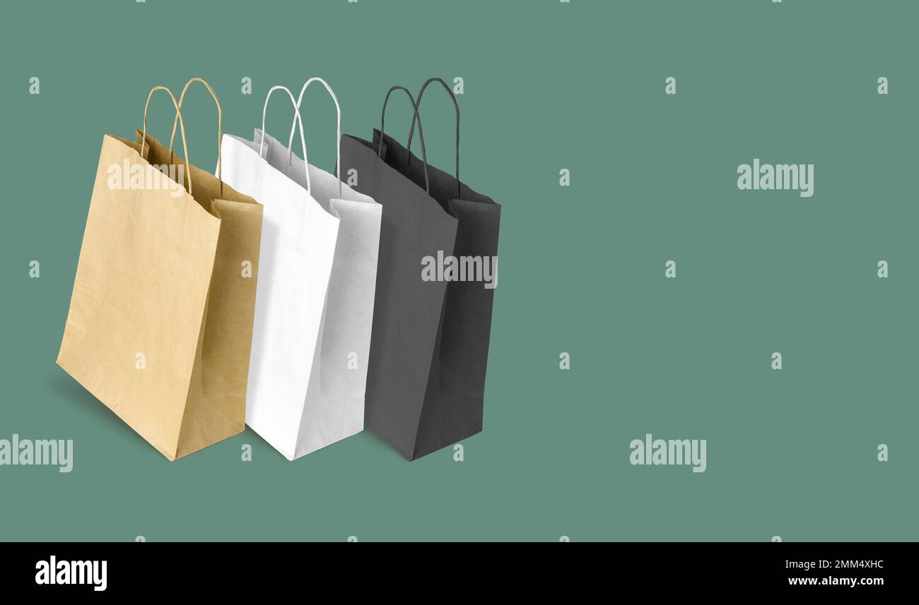 Sacchetti di carta per lo shopping su sfondo verde. Spazio di copia Foto Stock