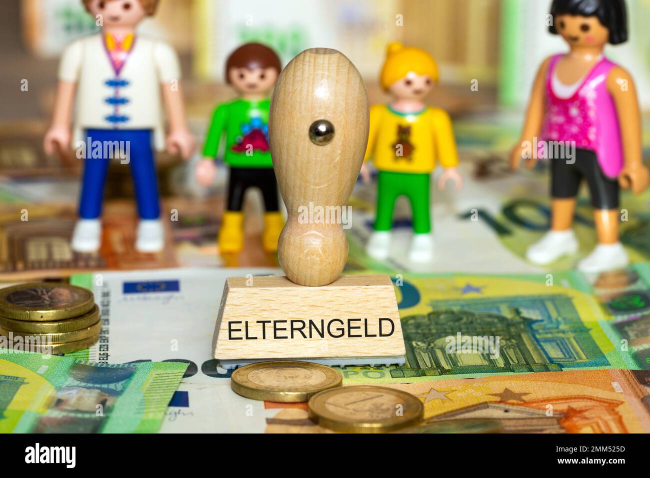 Immagine simbolo del assegno parentale: Banconote in euro, pezzi di gioco e un timbro con la parola Elterngeld (assegno parentale) Foto Stock