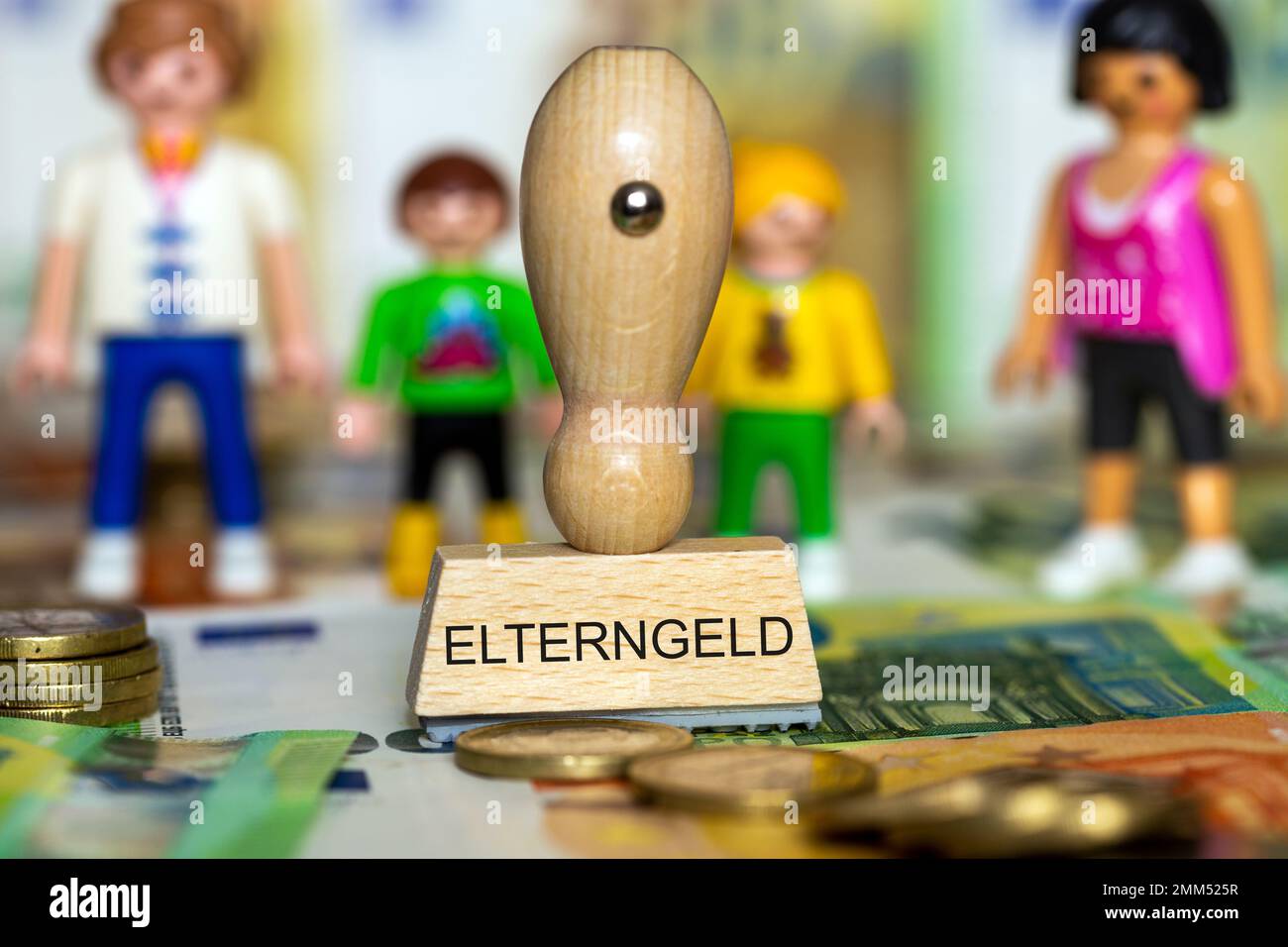 Immagine simbolo del assegno parentale: Banconote in euro, pezzi di gioco e un timbro con la parola Elterngeld (assegno parentale) Foto Stock