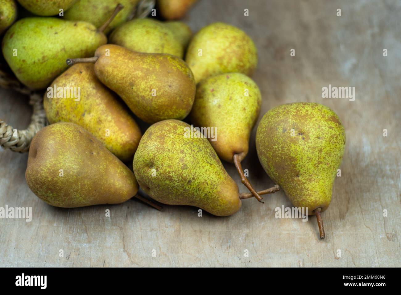 Pere in cesto su uno sfondo di legno. Raccolta di frutta. Autunno ancora vita. Pear Variety Bera Conference. Cibo vitaminico. Foto Stock