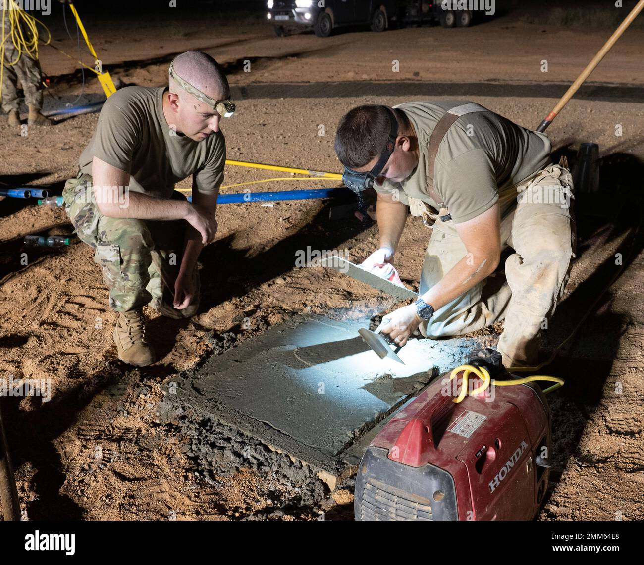 Christopher Dunn (a sinistra), 409th Air Expeditionary Group Air Operations Flight Commander, impara a bordo del cemento dal personale dell'aeronautica statunitense Sgt. 201 Craig Monfee (a destra), 724th Expeditionary Air base Squadron Civil Engineer Flight Pavements and Equipment Craftsman, presso Air base 201, Niger, 14 settembre 2022. Questo nuovo calzino a vento consentirà al campo di essere potenzialmente certificato dall'Organizzazione dell'aviazione civile internazionale (ICAO). Foto Stock