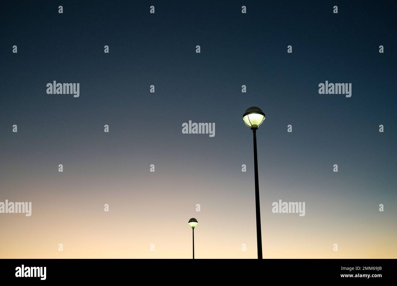 Lampioni luminosi contro il cielo della sera Foto Stock