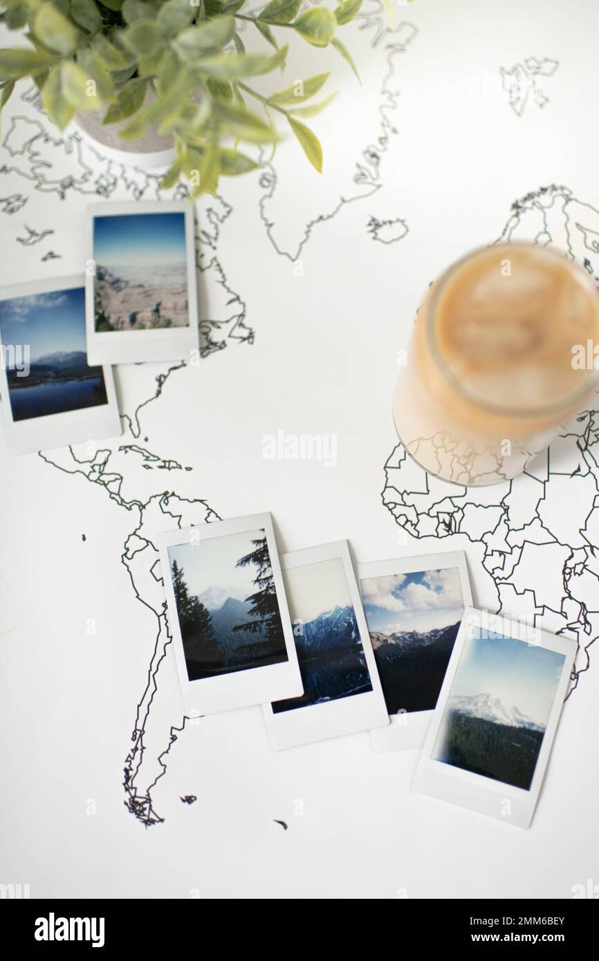 Polaroid Foto sulla mappa del mondo di viaggio con caffè freddo e pianta Foto Stock