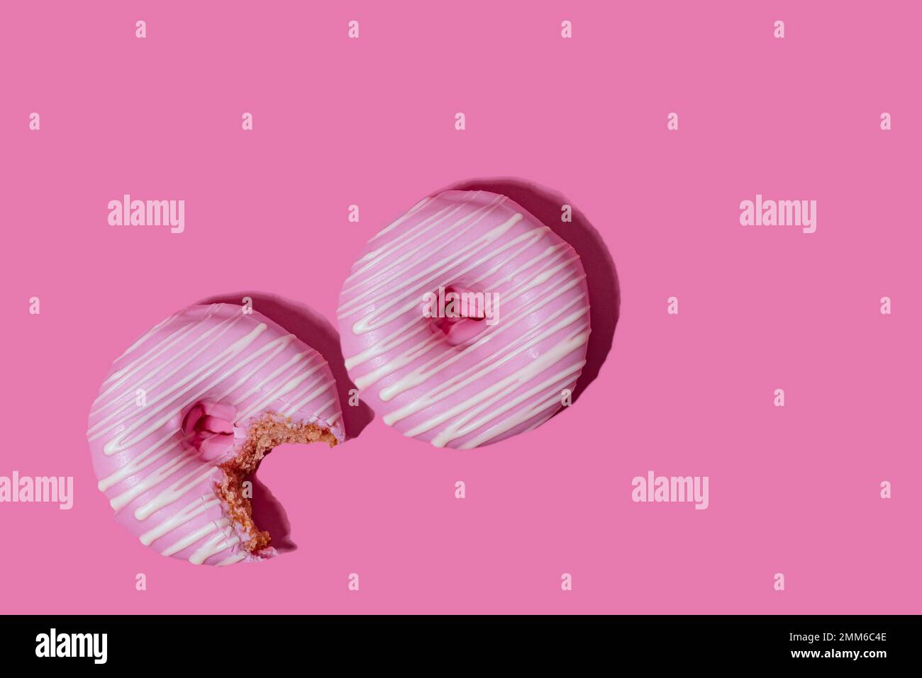 ciambella di lampone in smalto rosa su sfondo rosa. ripetizione. Foto Stock