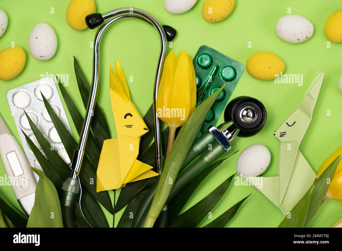 Pasqua felice e sana - scheda medica con stetoscopio e pillole, coniglietto di Pasqua e uova Foto Stock