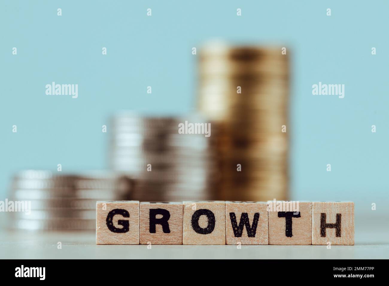 Accumulo crescente di monete, crescita scritta su blocchi di legno, concetto di aumentare il tasso di interesse, crescita degli investimenti, ottenere dividendi nel business Foto Stock
