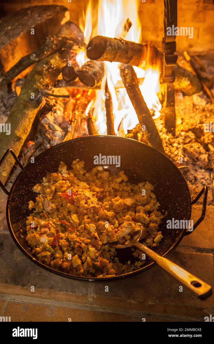 La casseruola di migas spagnola è cucinata al camino. Messa a fuoco selettiva Foto Stock