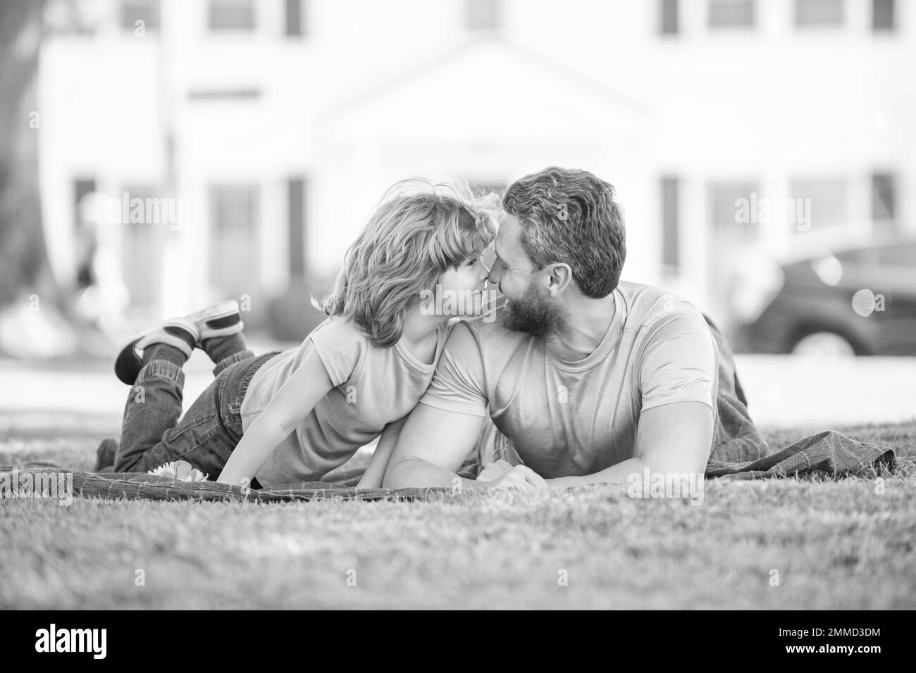 papà felice con figlio rilassarsi insieme su erba verde parco, paternità Foto Stock