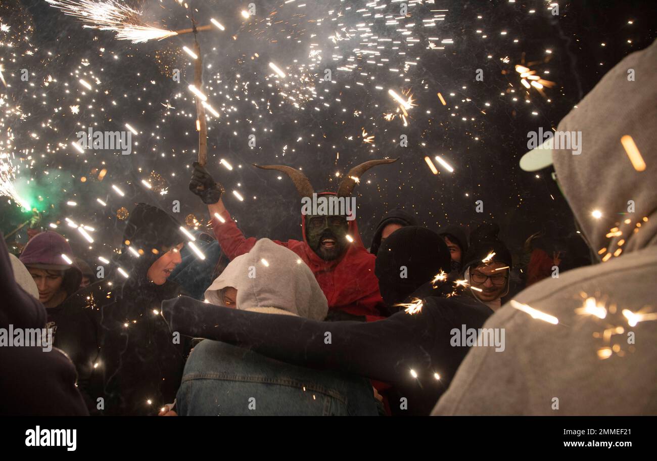 Palma, Spagna. 29th Jan, 2023. Un uomo vestito come un demone, in possesso di un fuochi d'artificio, cammina tra le persone durante il tradizionale Correfoc alla fine della festa annuale della città in onore della città di san Sebastià (San Sebastiano). Secondo gli storici, la tradizione dei diavoli del fuoco, che esiste anche sulla terraferma in Catalogna e Valencia, ha origini sia pagane che religiose. Credit: Clara Margais/dpa/Alamy Live News Foto Stock