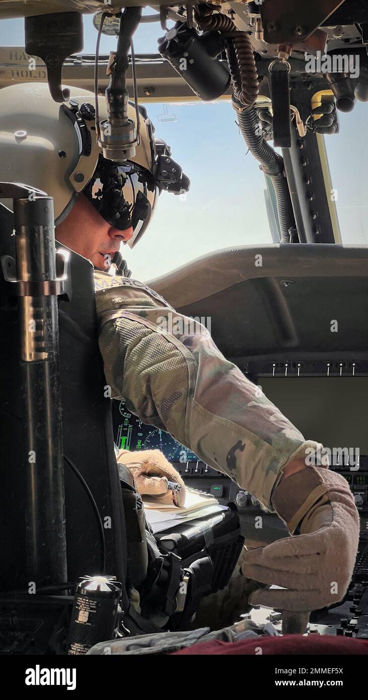 Chief Warrant Officer 2 James Marchetti, a Troy, NY, nativo, E UH-60m Black Hawk Pilot for A Company, 3-142nd Battaglione di elicottero d'assalto (AHB), con sede a Latham, New York, regola un interruttore sulla console centrale di un UH-60m Black Hawk durante un volo di addestramento nelle vicinanze di Camp Buehring, Kuwait, 16 settembre 2022. Marchetti e il suo equipaggio hanno esaminato le zone di atterraggio nelle vicinanze di Camp Buehring durante il loro volo. 3-142nd AHB, attaccato a 36th Brigata dell'Aviazione di combattimento, attualmente sostiene la missione congiunta combinata di risoluzione - operazione inerente per consigliare, assistere e abilitare partn Foto Stock