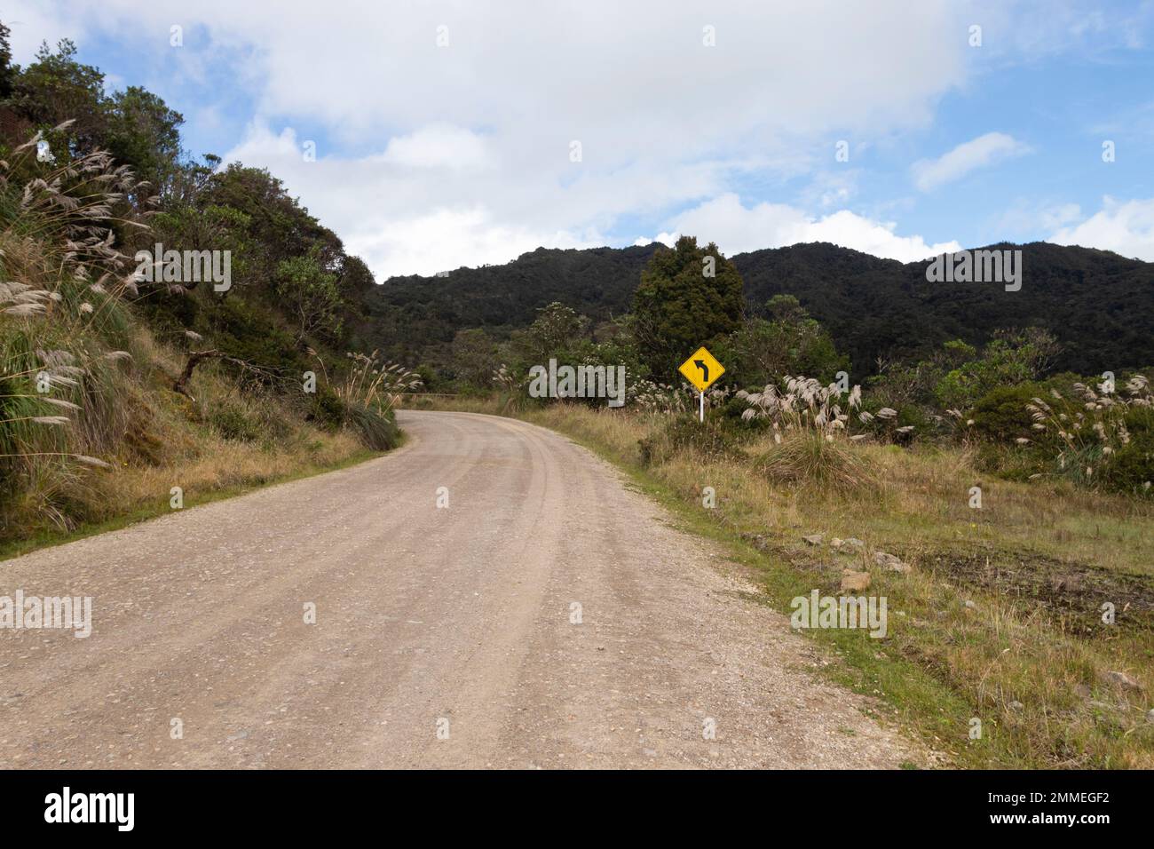 CHINGAZA, COLOMBIA - campagna strada di sabbia con segnale di traffico a sinistra nel mezzo del parco nazionale colombiano chingaza Foto Stock