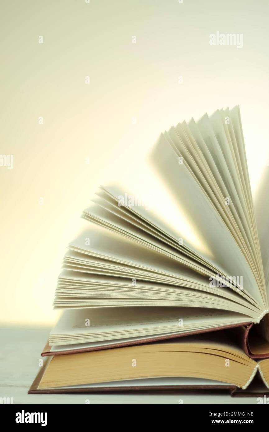 Letteratura e lettura . Lettura libri.Apri libri su uno sfondo chiaro con un giallo gradiente.pila di libri su un tavolo di legno.apprendimento e la conoscenza Foto Stock