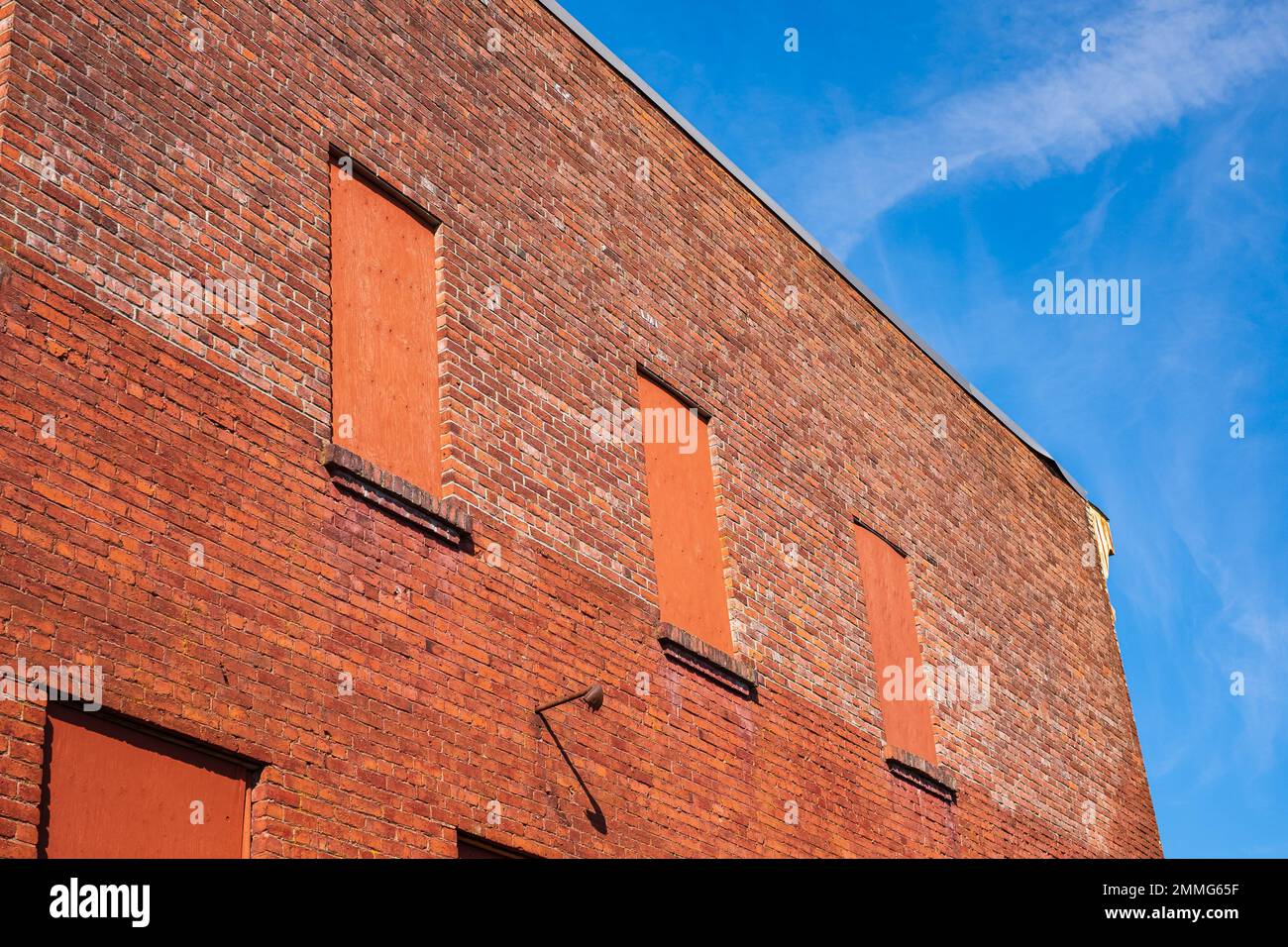 Vecchio muro di mattoni con finestre piene di mattoni. Muro di mattoni rossi una fabbrica con quattro finestre in mattoni con spazio per il testo. Casa muro di mattoni. Foto strada, n Foto Stock