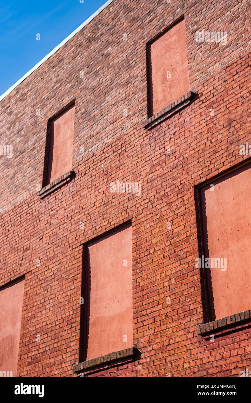 Vecchio muro di mattoni con finestre piene di mattoni. Muro di mattoni rossi una fabbrica con quattro finestre in mattoni con spazio per il testo. Casa muro di mattoni. Foto strada, n Foto Stock