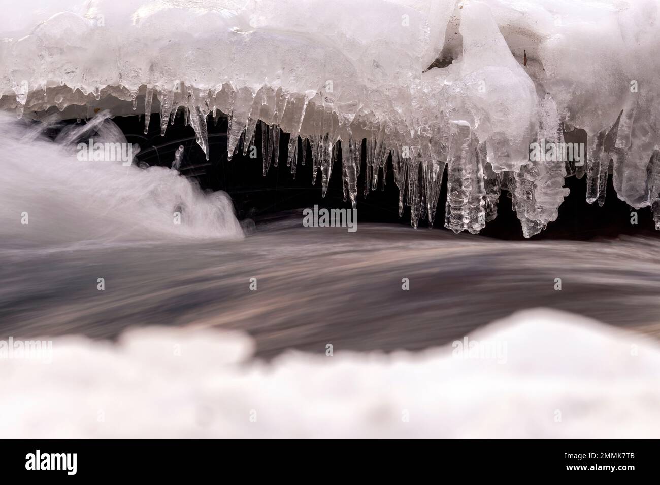 Immagine astratta dell'acqua che scorre attraverso rocce ricoperte di ghiaccio - Clear Creek, Golden, Colorado, USA Foto Stock