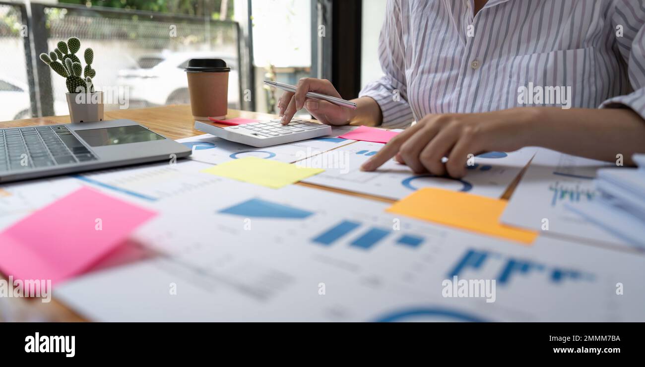 Financial Businesswomen analizza il grafico delle prestazioni dell'azienda per creare profitti e crescita, le relazioni di ricerche di mercato e le statistiche sul reddito Foto Stock