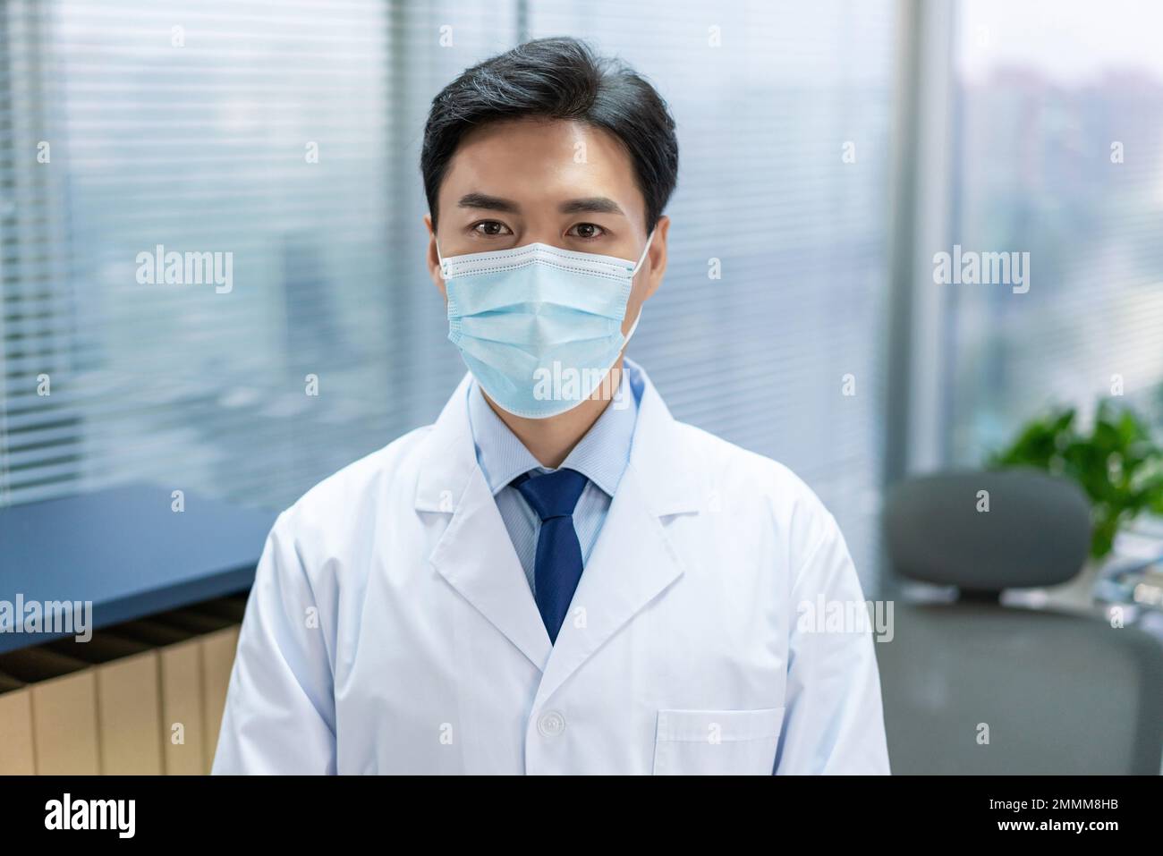 Il giovane medico indossava maschere lavora in un ufficio Foto Stock