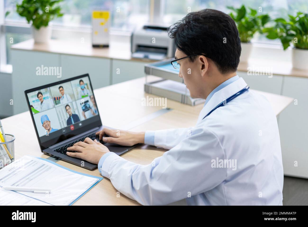 Il giovane medico che lavora in ufficio Foto Stock