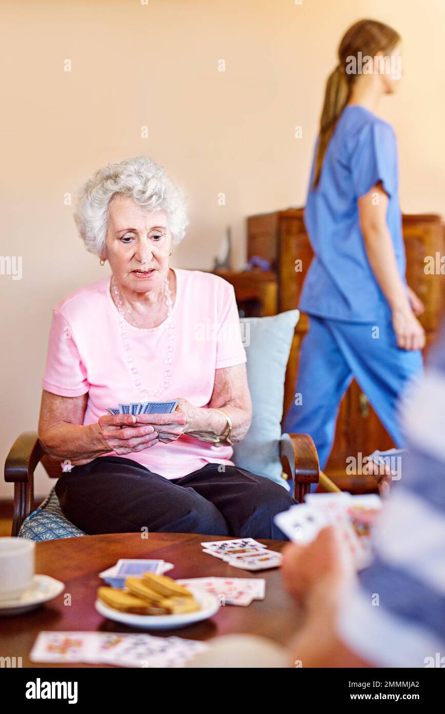 In attesa della mossa successiva. le carte da gioco degli anziani nella loro casa di riposo. Foto Stock