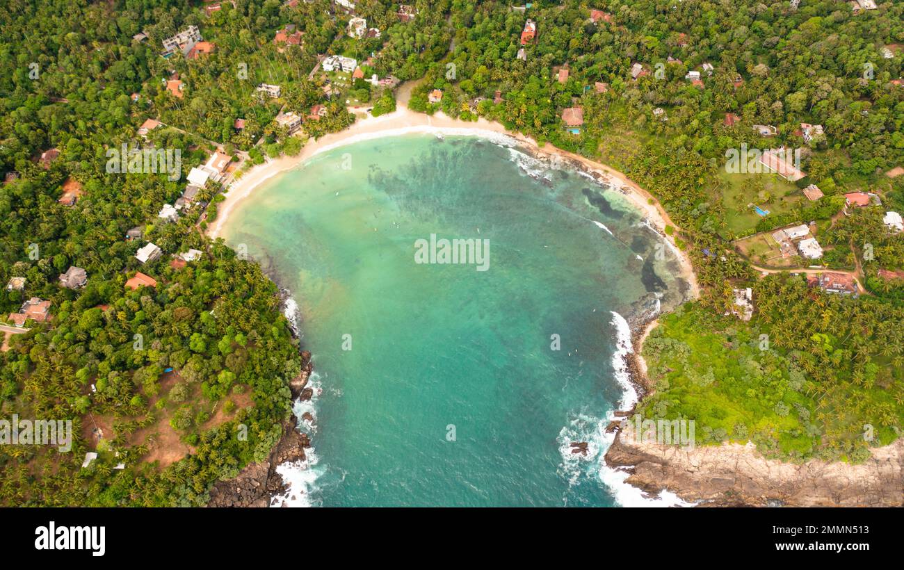 Drone aereo di baia con una spiaggia di Hiriketiya tra palme. Surf spot in Sri Lanka. Foto Stock