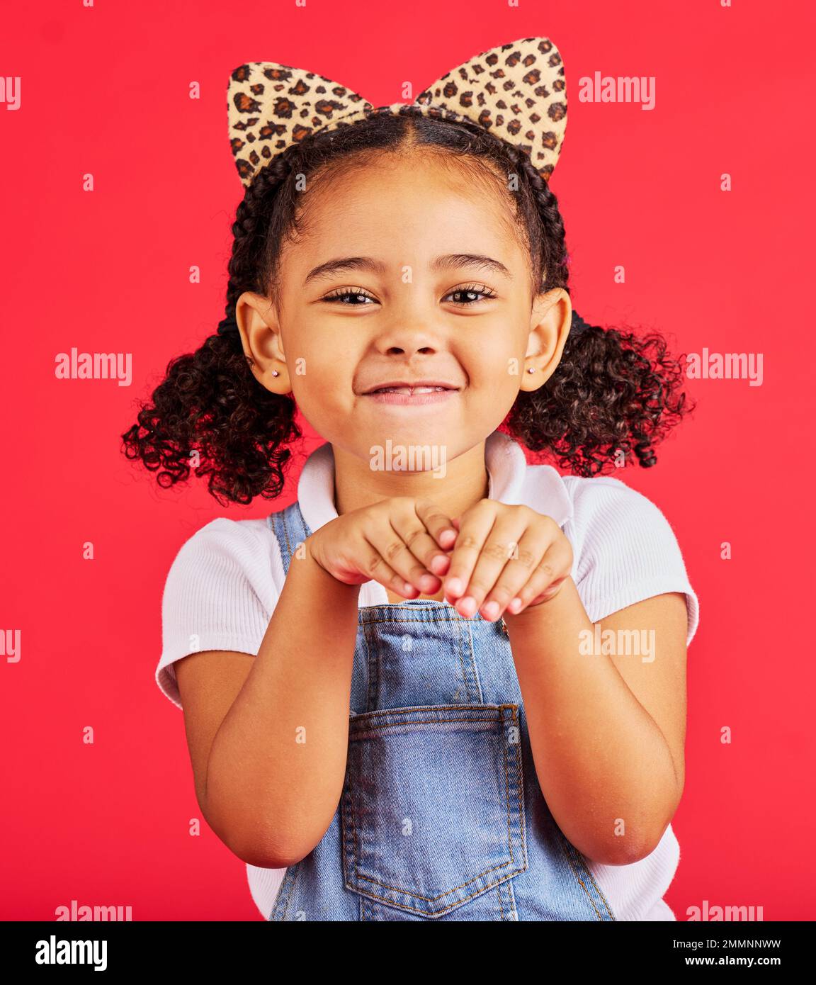 Ragazza, ritratto e leopardo fascia in studio per abito fantasia, fingere di giocare e immaginazione su sfondo rosso. Bambini felici, stampa di animali moda Foto Stock