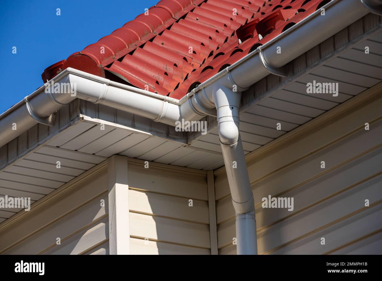 Edificio Casa moderna costruzione con angolo tetto in metallo, sistema di gocciolatoio e protezione del tetto da snowboard, barra di neve Snow Guard. Paraneve sul tetto Foto Stock