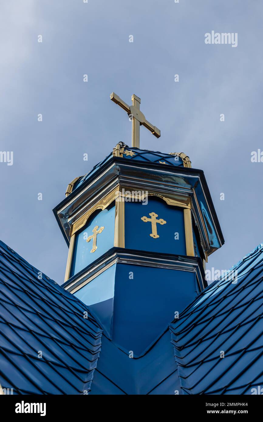 Primo piano di una Croce su una chiesa cristiana su sfondo blu. Foto Stock