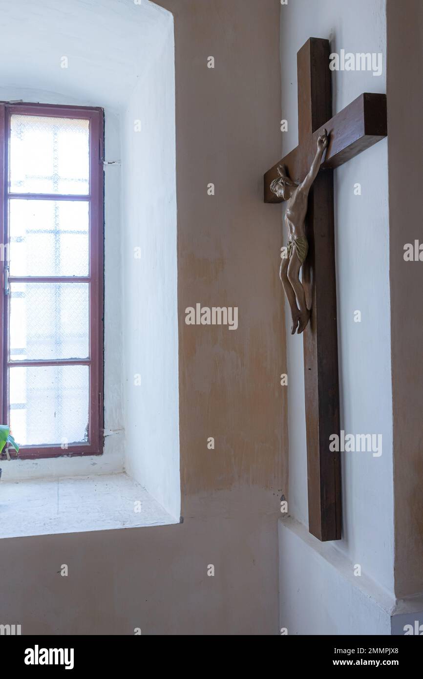 Gesù cristo sulla croce con sfondo muro nella chiesa cattolica. Foto Stock