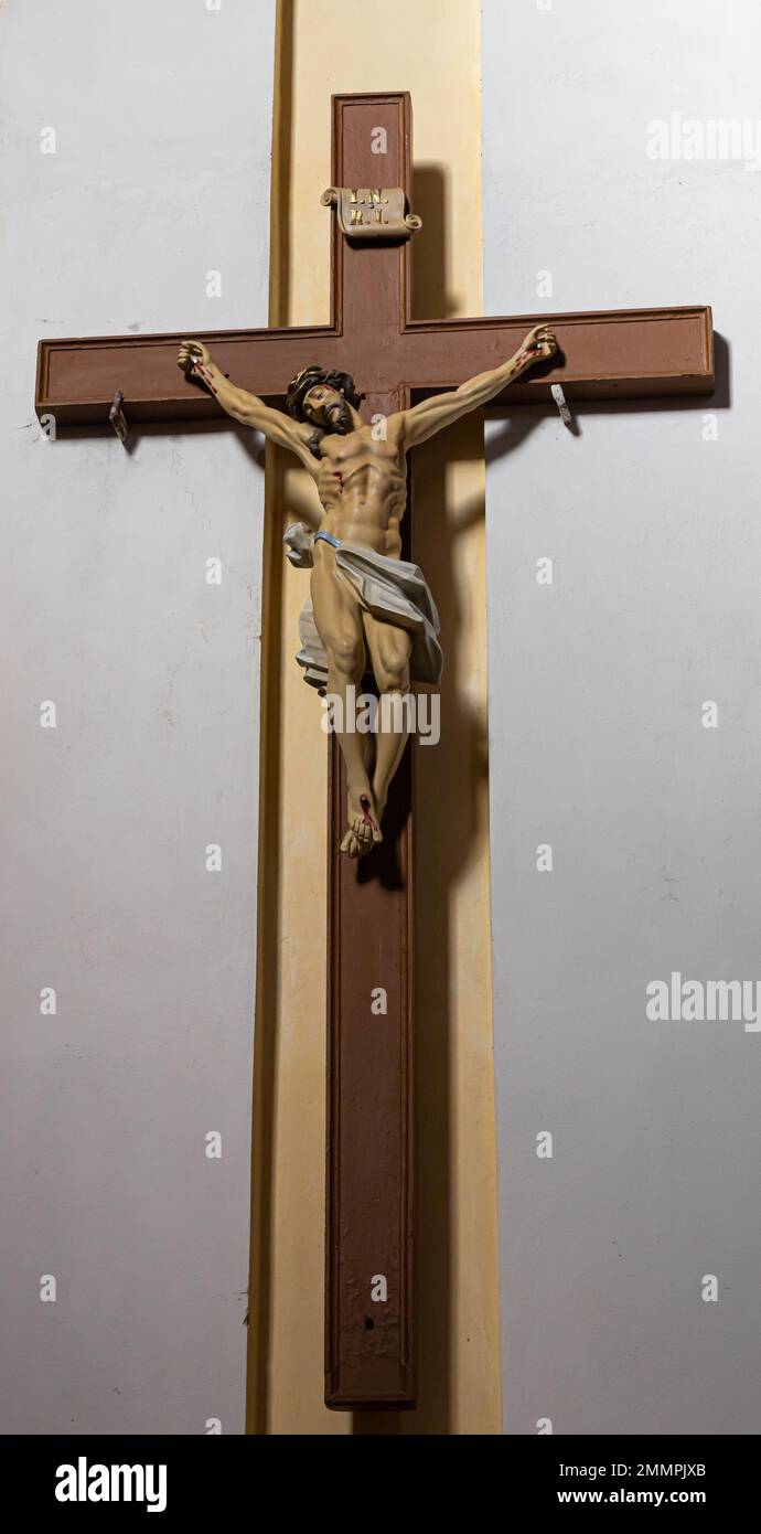 Gesù cristo sulla croce con sfondo muro nella chiesa cattolica. Foto Stock