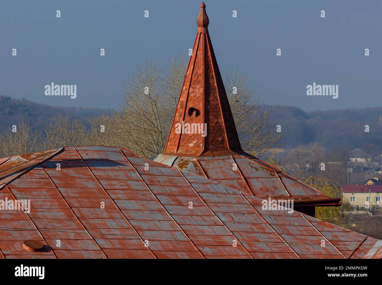 Il tetto della casa è fatto di tegole di metallo rosso, un bel grande camino. Foto Stock