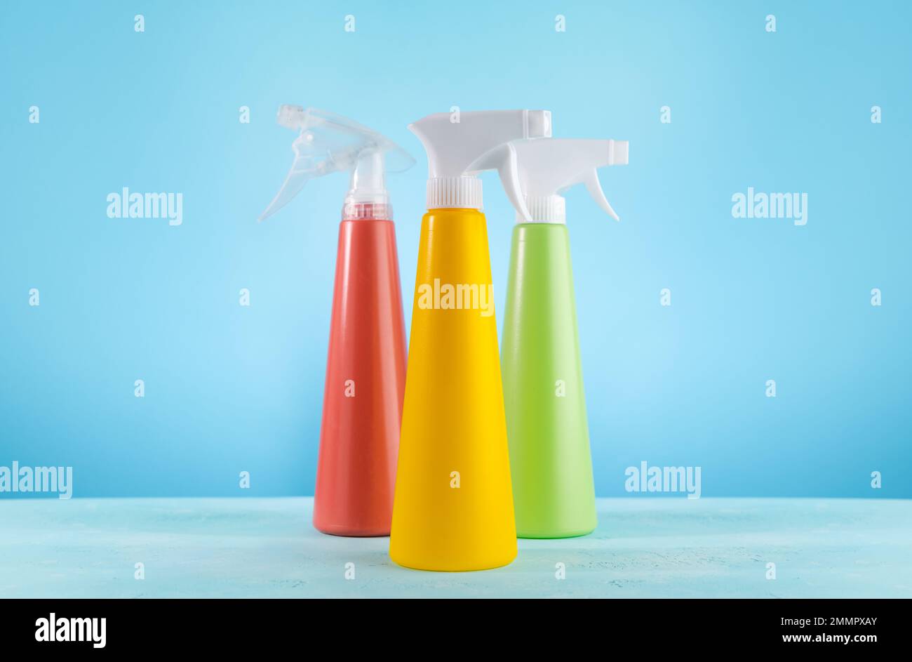 Spray per la pulizia bottiglie di detergente e bolle SOAP.Concept of Spring Cleaning Home. Materiali di consumo colorati per la pulizia su sfondo blu. Foto Stock