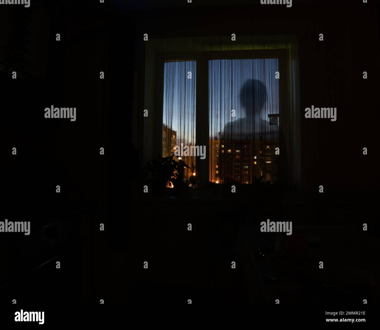 Shadow silhouette di un uomo nella finestra notturna, sfondo scuro, spazio copia. L'idea di pericolo, solitudine, qualcuno che spionda Foto Stock