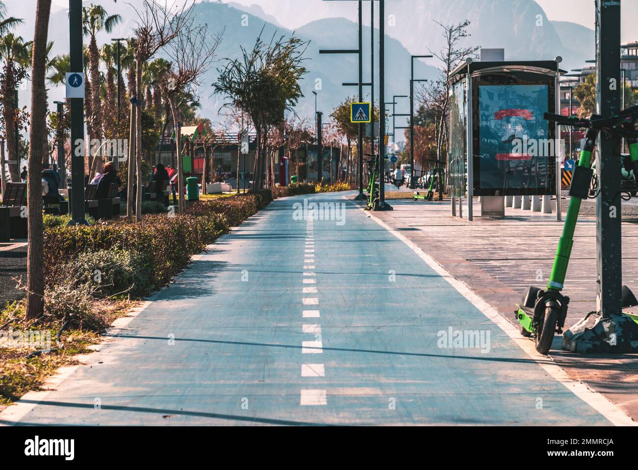 Percorso ciclabile blu vuoto e scooter elettrico in piedi accanto ad esso in una nuvolosa giornata autunnale Foto Stock