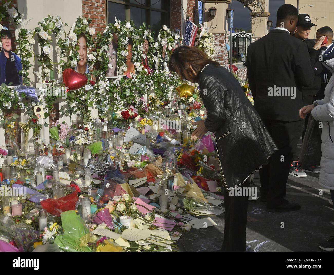 Monterey Park, Stati Uniti. 29th Jan, 2023. Una donna si inchina prima dei ritratti di Monterey Park che sparano alle vittime uccise durante una celebrazione di Capodanno lunare, mentre i residenti della comunità di Alhambra-Monterey Park continuano a piangere allo Star Ballroom Dance Studio di Monterey Park, California, domenica 29 gennaio 2023. Foto di Jim Ruymen/UPI Credit: UPI/Alamy Live News Foto Stock