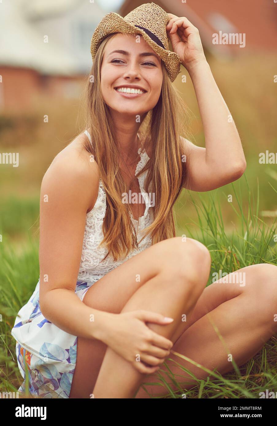 Trova la felicità nelle cose più semplici. una giovane donna seduta in un campo in campagna. Foto Stock