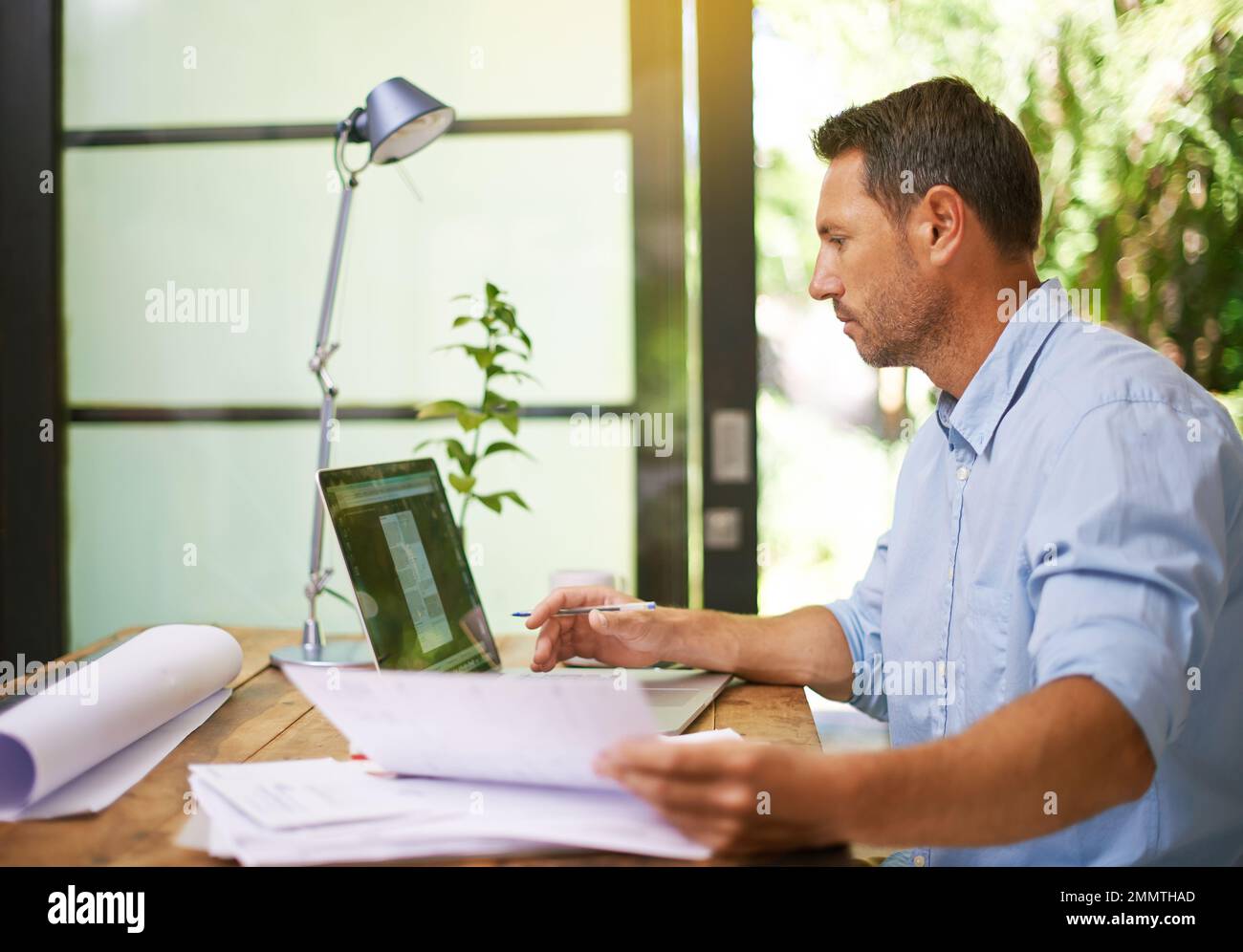 Passaggio dalla stampa al digitale. un giovane che lavora da casa. Foto Stock