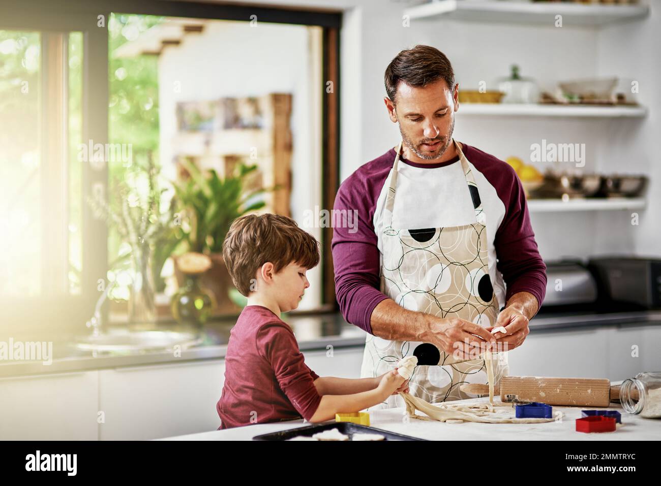 Papà, sai che cosa fai. un padre e un figlio che cucinano biscotti in cucina. Foto Stock