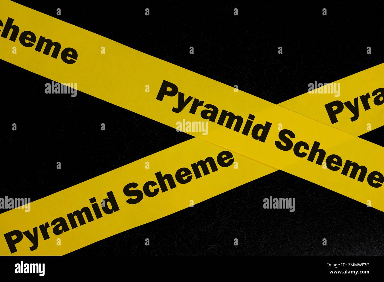 Sistema piramidale avviso, attenzione e concetto di avvertimento. Nastro di barricata giallo con parola truffa su sfondo nero scuro. Foto Stock