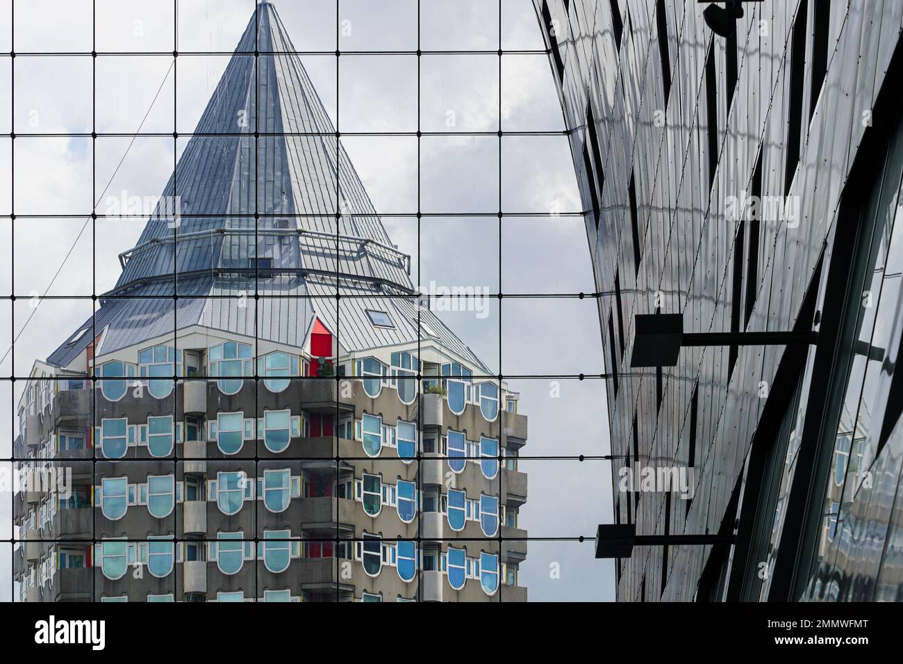 Riflesso della torre residenziale Blaak Tower dell'architetto Piet Blom nella facciata in vetro del mercato di Rotterdam, il Markthal. Foto Stock