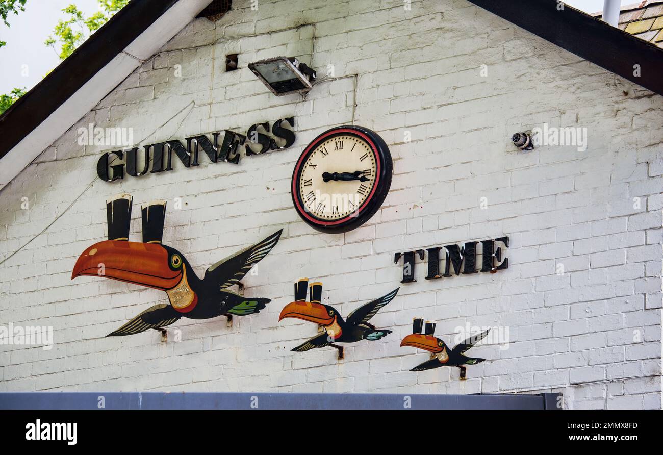 Guinness spot sul lato del locale che piume il 'Guinness Time' volo Toucans associato con il marchio Guinness. Foto Stock