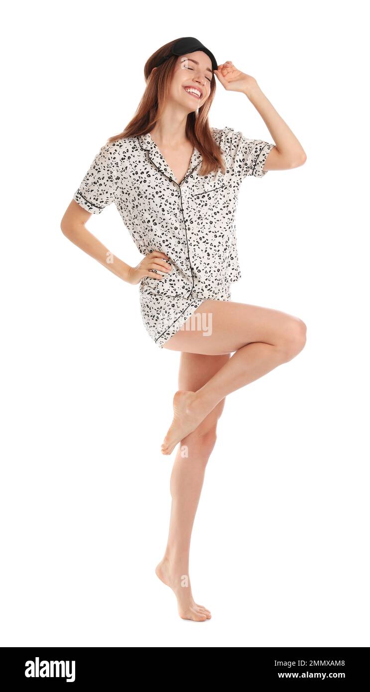 Bella donna che indossa pigiama e maschera del sonno su sfondo bianco. Ora di coricarsi Foto Stock