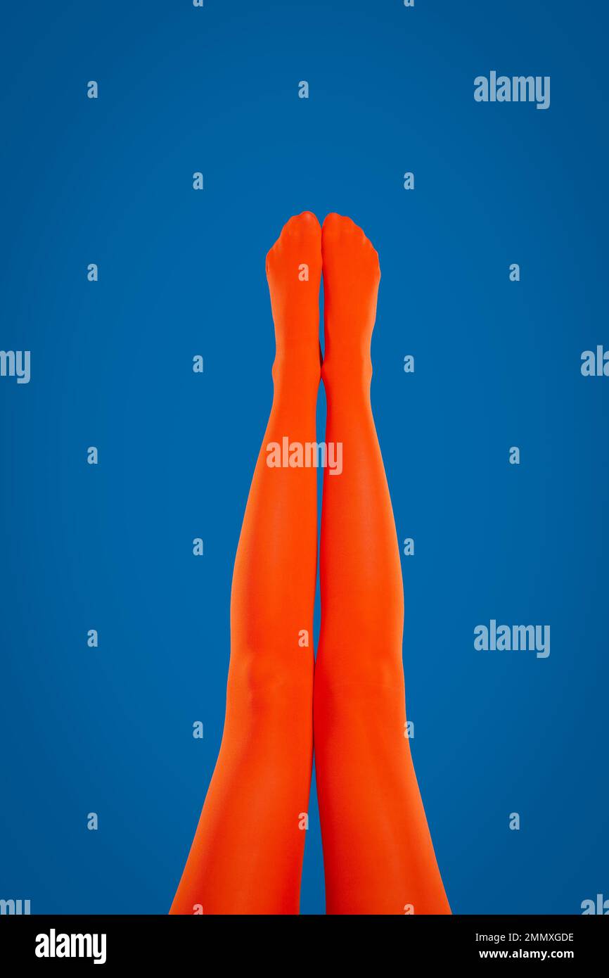Donna che indossa collant arancioni su sfondo blu, primo piano delle gambe  Foto stock - Alamy