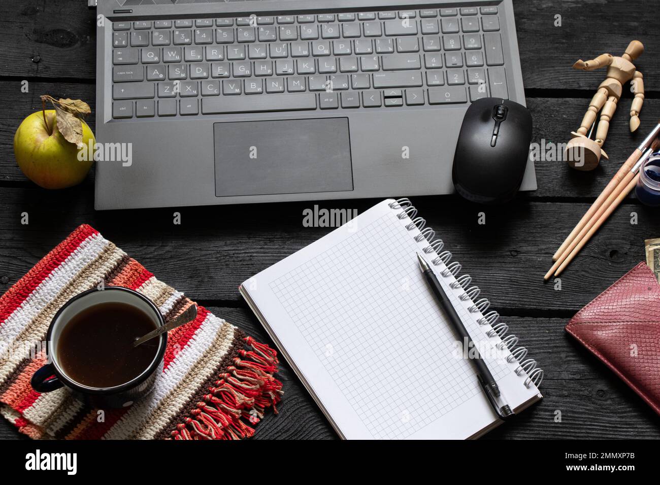 la tazza nera del blocco note del laptop con i soldi del caffè si trovano sul tavolo nero di legno di lavoro, sul laptop sul tavolo di lavoro durante il lavoro, sul processo creativo, sul freelance Foto Stock