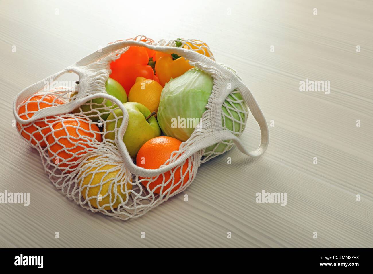 Borsa a rete con verdure e frutta su tavola di legno Foto stock - Alamy