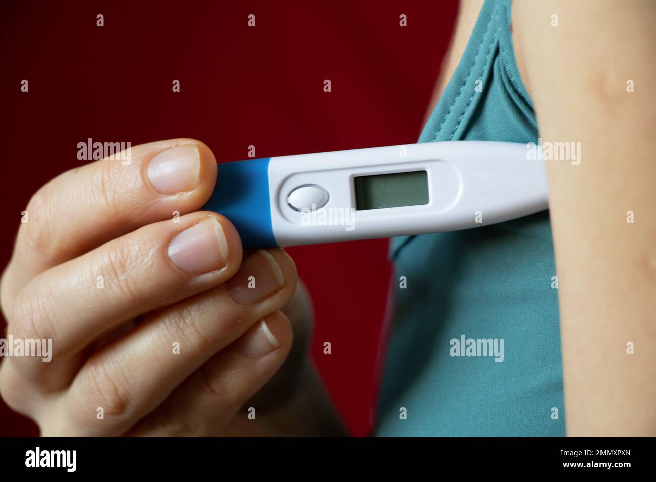 ragazza giovane con un termometro in mano, alta temperatura, febbre e febbre, pandemia mondiale, polmonite, termometro Foto Stock