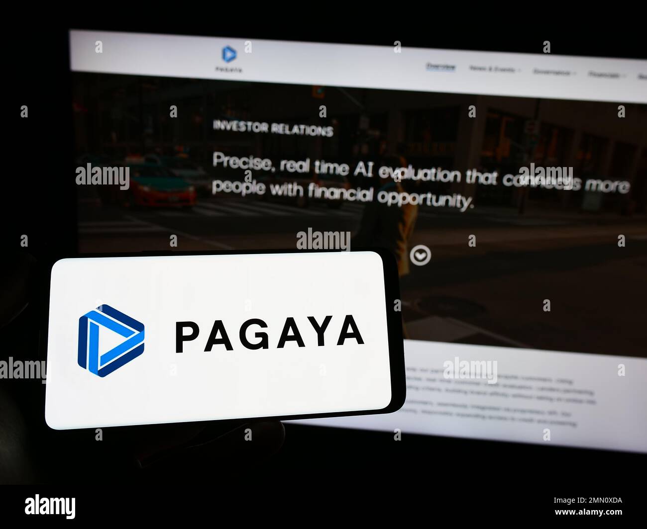 Persona che tiene lo smartphone con il logo della società finanziaria Pagaya Technologies Ltd. Sullo schermo di fronte al sito Web. Messa a fuoco sul display del telefono. Foto Stock