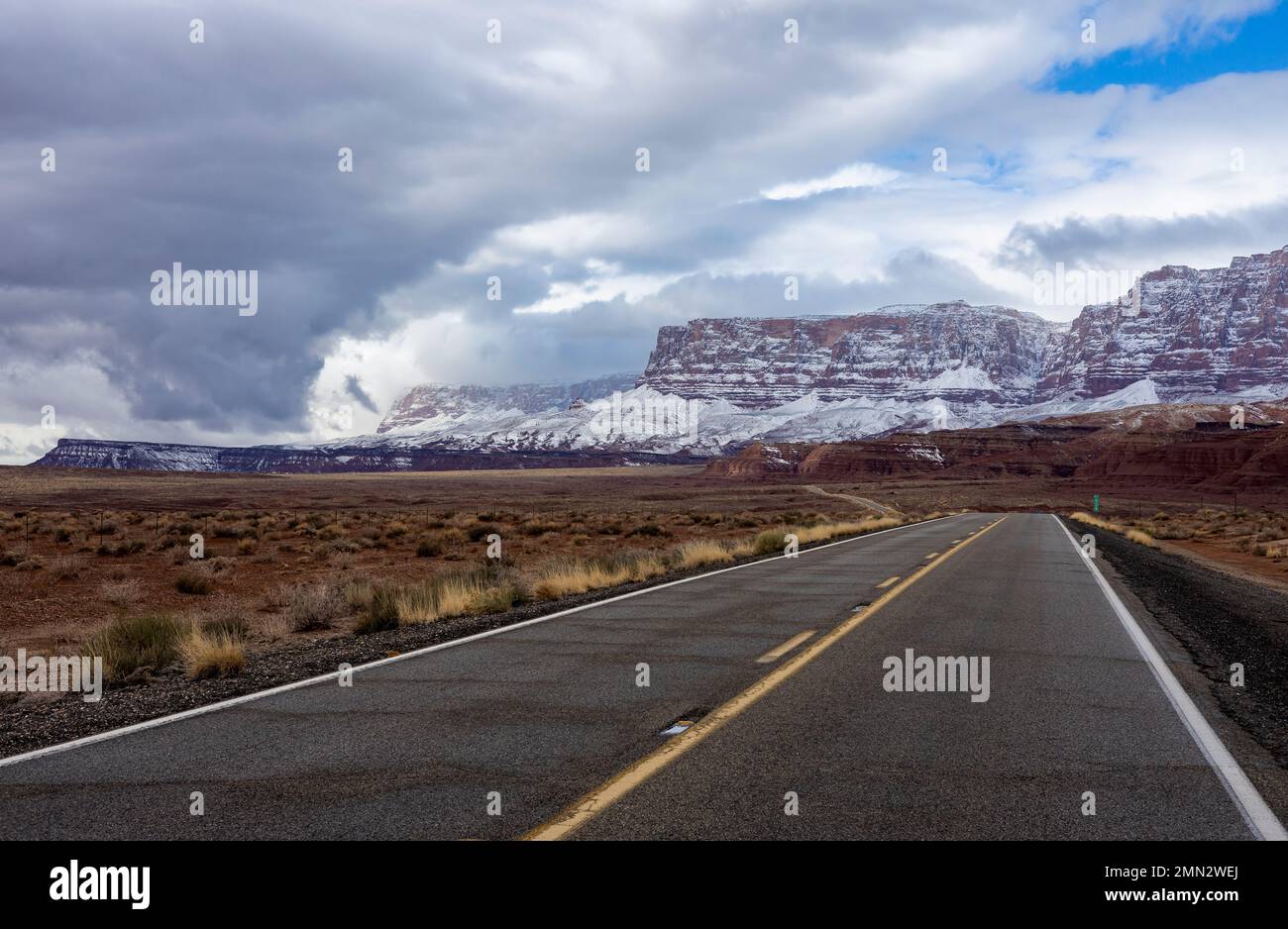 Autostrada 89a a Marble Canyon, Arizona, con le scogliere Vermilion coperte di neve sullo sfondo Foto Stock